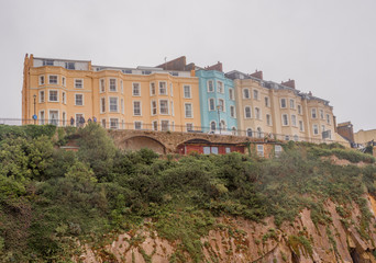 Colourful houses perched high on the cliffs at Tenby south beach, Tenby, Wales, UK
