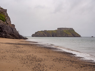 Small island off the coast at Tenby South Beach, Tenby, Wales, UK