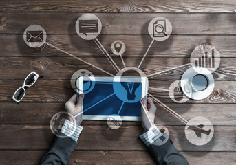 Business workplace with tablet device in female hands and media user interface