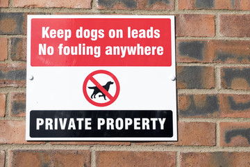 Keep dogs on leads and no fouling sign on residential wall