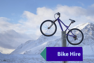 Bike hire sign and mountain bicycle winter Glencoe Highlands Scotland