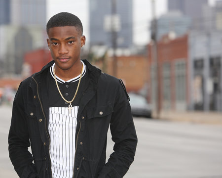 Street scene young African American male model against Dallas Texas skyline.