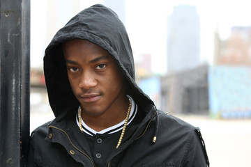 Street scene young African American male model wearing hoodie against Dallas Texas skyline. - obrazy, fototapety, plakaty