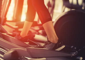 Exercise Elliptical cardio running workout at fitness gym of woman