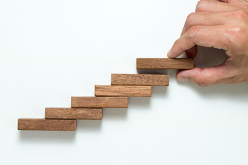 Man hand stacking up wooden block