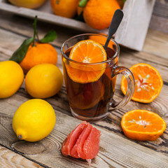 Citrus and fruit tea with ginger on a wooden background. Drink to be warmed in the winter