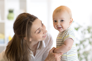 Happy child near to mom in her room