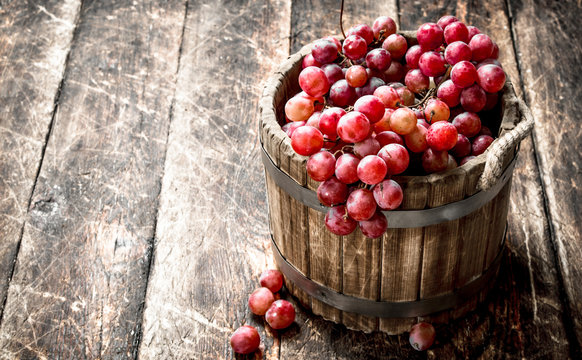 Red grapes in a wooden bucket.