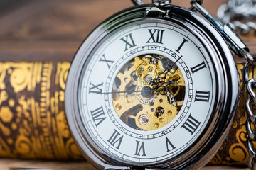 Closed up vintage pocket watch on book using as time symbol or business deadline concept