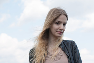 Girl with blond hair and blue sky and white cloud