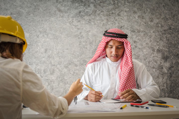 Arab engineer working with workmate in contractor office