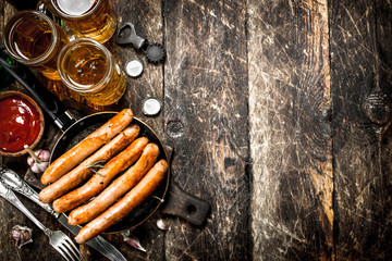Sausages with cold beer and sauce.