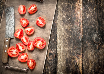 Fresh tomatoes with a knife in the old tray.