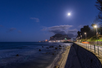 Fototapeta premium Vista notturna della spiaggia di Cefalù con la cittadina sullo sfondo, Sicilia