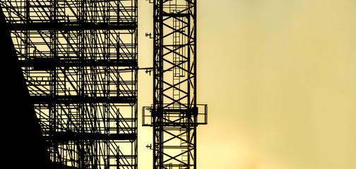 silhouette scaffolding with copy space for text, building construction, black profile structure of scaffolding warm orange colors sunset, construction, architecture engineering