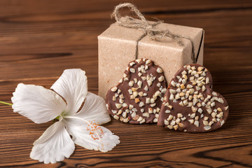 Fototapeta na wymiar box, dark chocolate heart and hibiscus flower, Valentines day concept