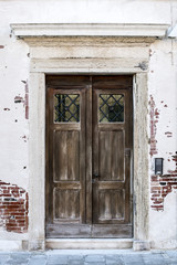 Wooden old entrance door to house, Main input to old building, Shabby front door background, Wooden door in an old renaissance house