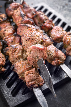 Traditional Russian shashlik on a barbecue skewer as top view on grillage