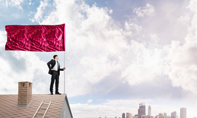 Young businessman with flag presenting concept of leadership. Mixed media