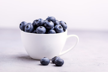 Fresh Raw Organic Farm Blueberry in Cup on white kitchen Background Copy Space