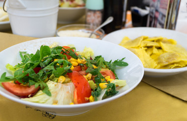 Italian-style salad, Insalata, served on a white plate in italian restaurant. Close-up.