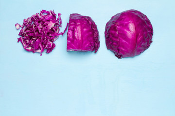 Purple Cabbage half and slice. space. on wood clor blue sky background