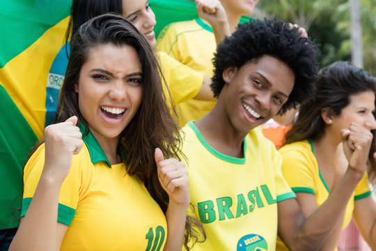 Jubelnde brasilianische Fussball Fans mit Fahne