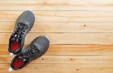 pair of black sneaker shoes on wooden background