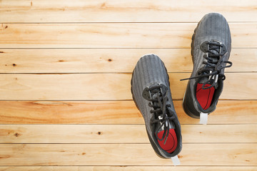 pair of black sneaker shoes on wooden background