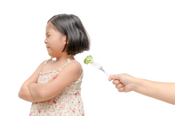 girl with expression of disgust against vegetables isolated
