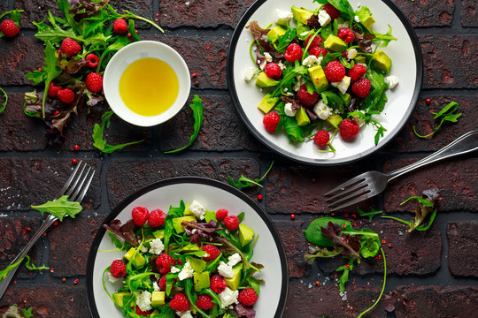 Fresh Tasty Raspberry salad with avocado, green vegetables, nuts, feta cheese, olive oil and herbs. healthy food.