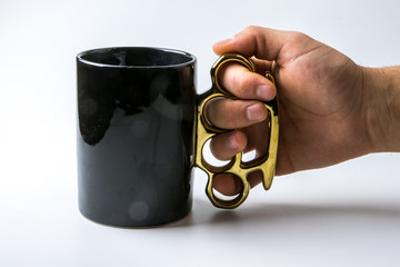 Symbol für Aggression: Mann Hand hält originellen Kaffeebecher mit Schlagring
