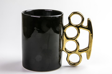 Skurriler Kaffeebecher mit Schlagring als Henkel