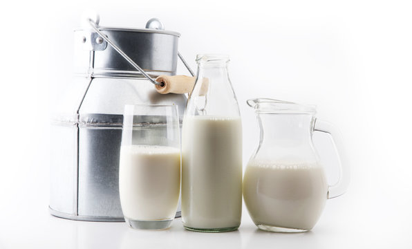 A jug of milk and glass of milk on white background.