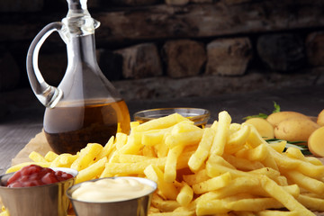 french fries, chips on wooden background with salt