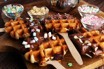Belgium waffles with chocolate sauce. popsicles with chocolate and wafer.