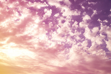 colorful purple sky with a bright sunset sun with lots of white clouds