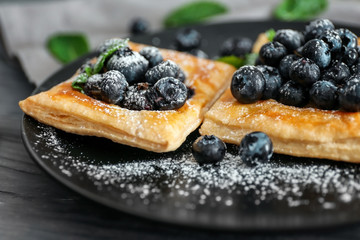 Tasty pastries with blueberries on plate, closeup