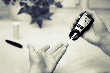 A medical test, checking a drop of blood on the sugar level.