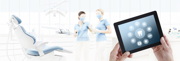 dentist hand touch digital tablet screen teeth icons and symbols on dental clinic with dentist's...