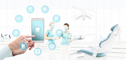 dentist hand touch smart phone screen, teeth icons and symbols on dental clinic with dentist's chair background web banner template