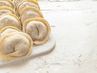 Traditional Russian handmade dumplings frozen on the board. Russian pelmeni. Ravioli