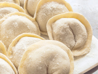 Traditional Russian handmade dumplings frozen on the board. Russian pelmeni. Ravioli