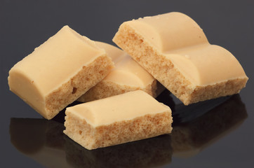 White milk chocolate macro on glossy black background