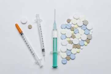 colorful tablet and disposable syringe on white background, closeup