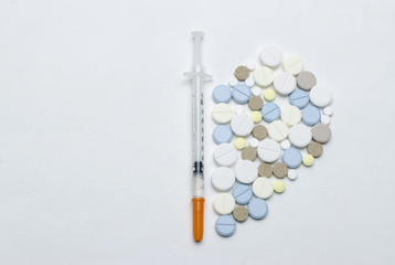 colorful tablet and disposable syringe on white background, closeup
