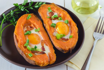 Baked sweet potato with fried egg, bacon and chives.