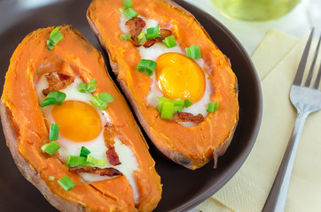 Baked sweet potato with fried egg, bacon and chives.