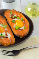 Baked sweet potato with fried egg, bacon and chives.