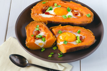Baked sweet potato with fried egg, bacon and chives.